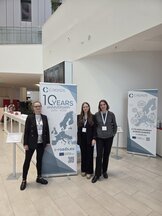 3 People of the C-Roads supporting Secretariat in front of a C-Roads roll-up